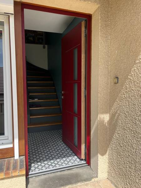 Porte d'entrée mixte aluminium et bois en rouge - vue extérieure Portes d'entrée mixte : porte d'entrée mixte aluminium et bois en rouge - vue extérieure. Wilco Yvelines 78
